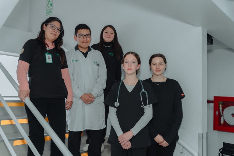 Five healthcare workers in medical uniforms and scrubs standing together on a staircase in a hospital